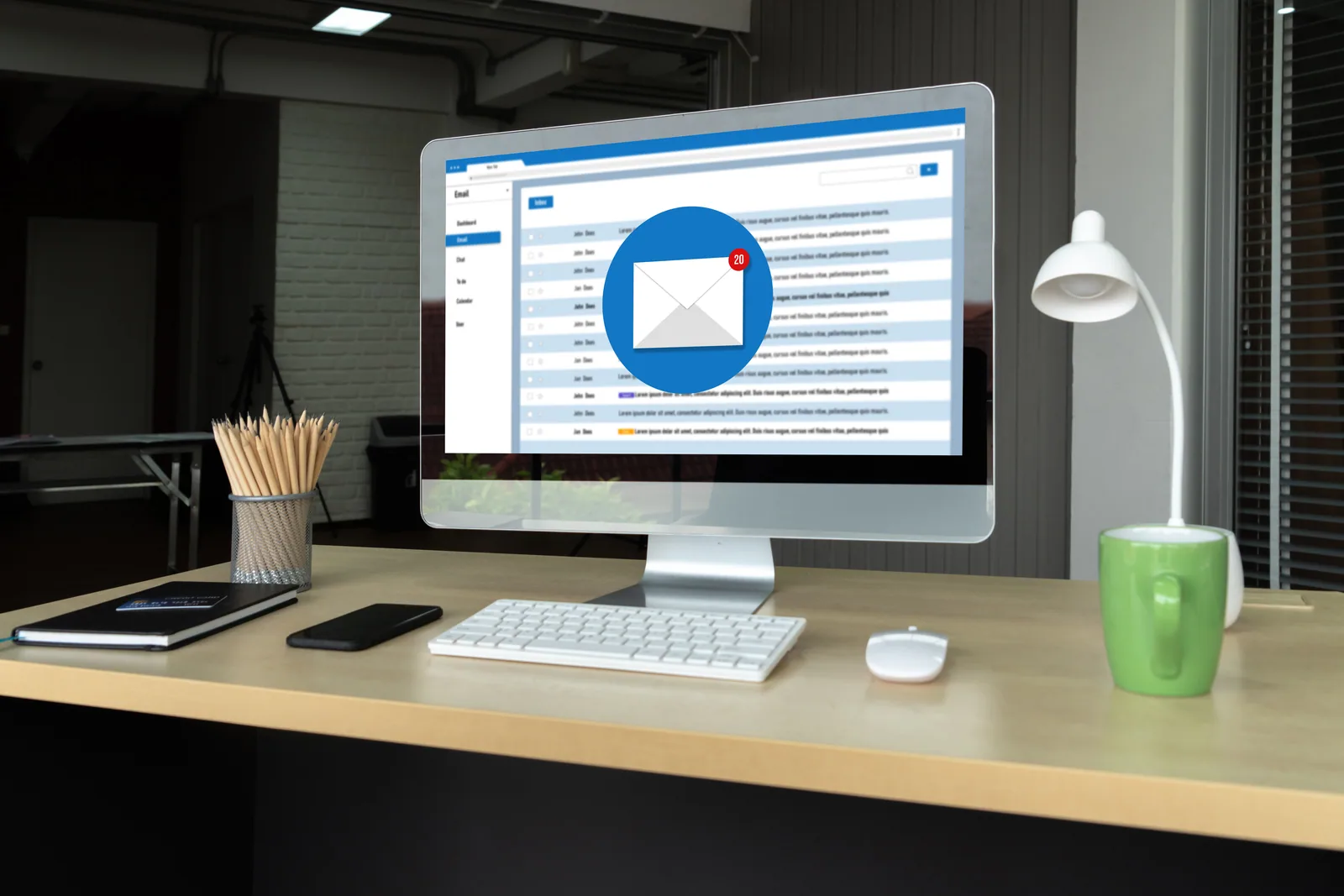 Ofis bilgisayarında açık e-posta kutusu Ofis masasındaki bilgisayar ekranında açık e-posta gelen kutusu ve yeni ileti bildirimi; iş e-postalarının izlenmesi konusunu anlatıyor