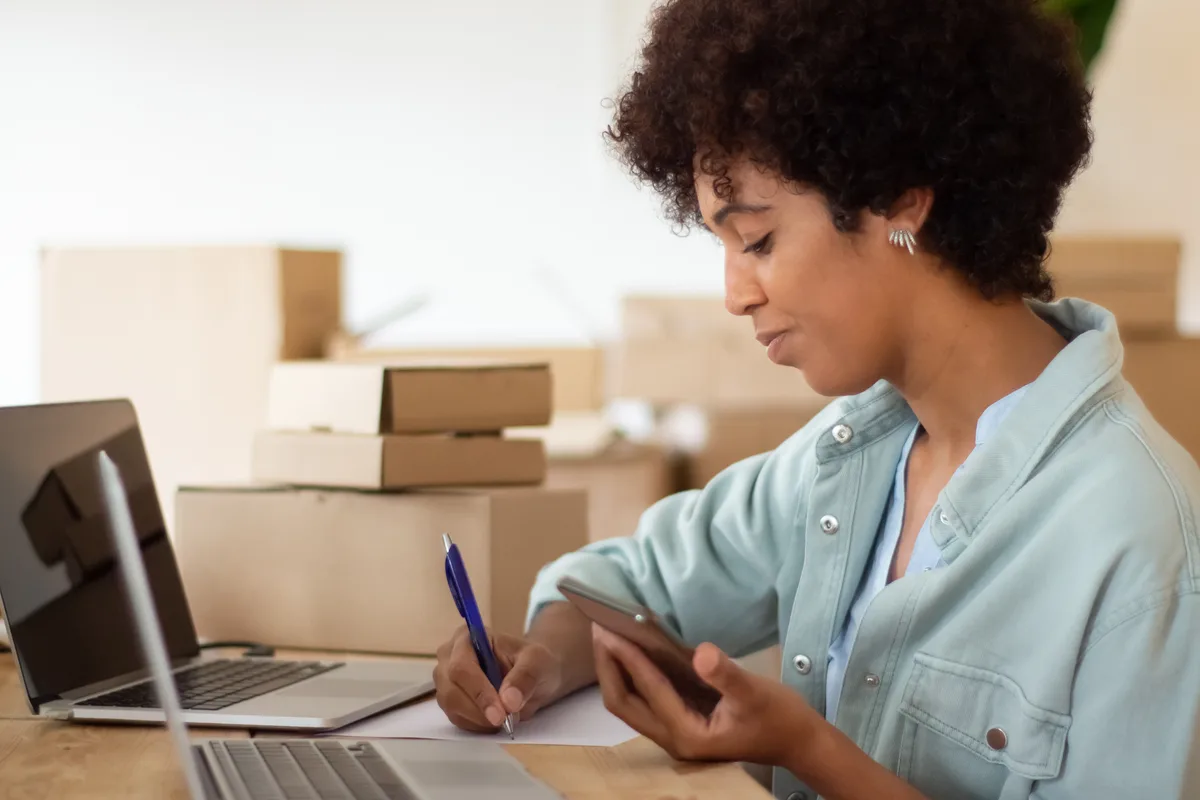 Kargo paketleri arasında sipariş detaylarını kontrol eden e-ticaret çalışanı — Sahada En Sık Karşılaştığımız Tablo Kargo paketleri arasında sipariş detaylarını kontrol eden e-ticaret çalışanı